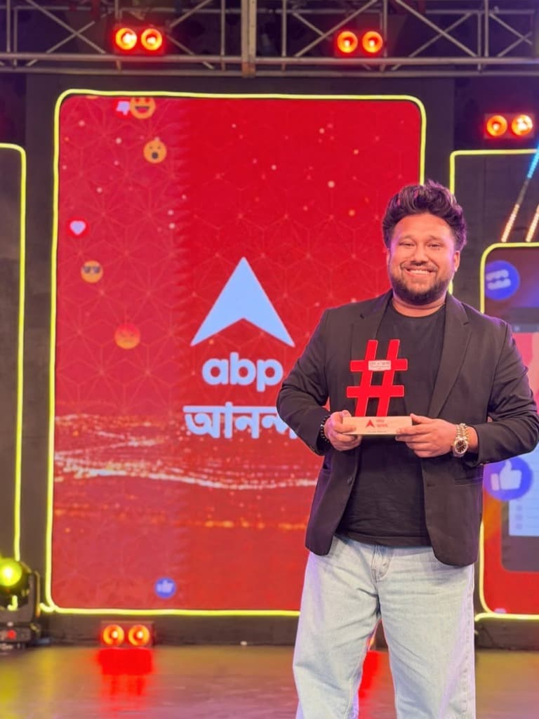 Sayan Chakraborty holding award from ABP Ananda